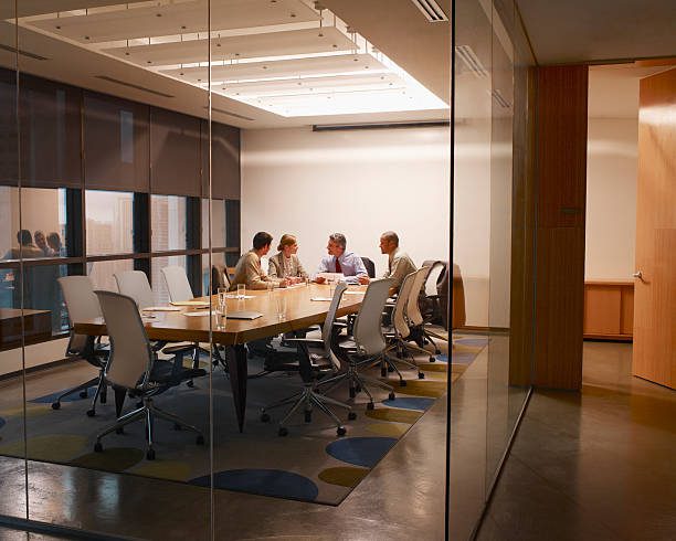 A group of people sitting at a table in an office.